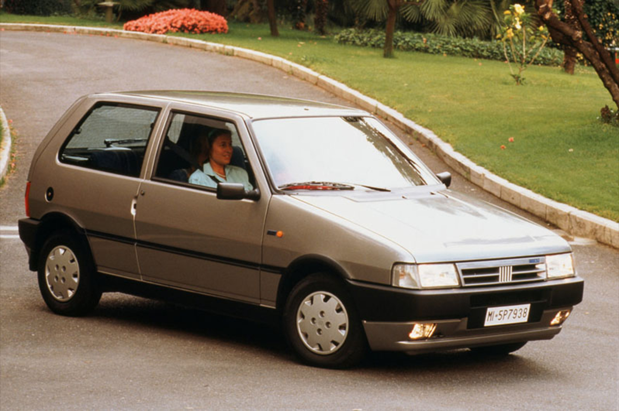 Fiat Uno anni Novanta accanto a una compatta moderna rossa