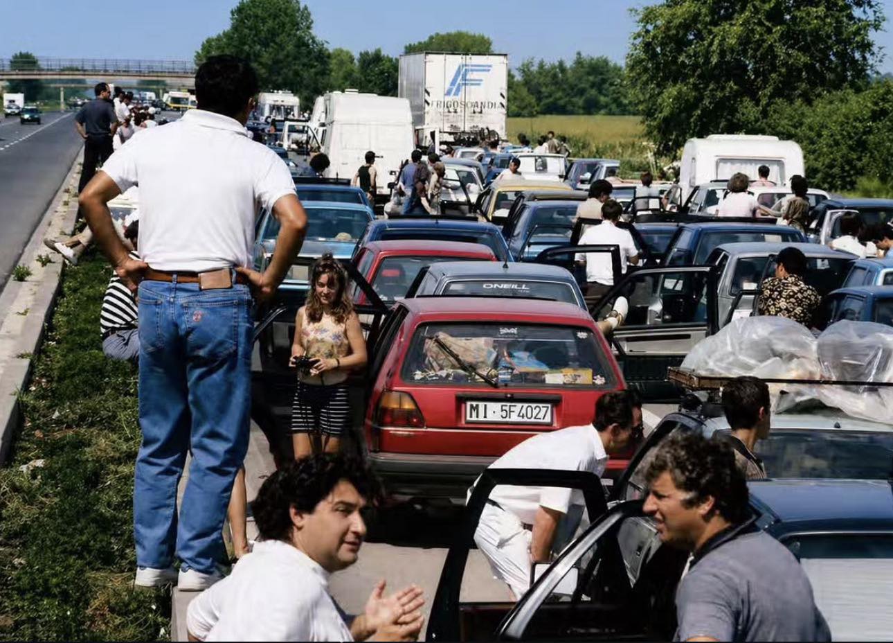 Traffico estivo sull’autostrada A1 negli anni Novanta, automobilisti scesi dalle auto durante un ingorgo