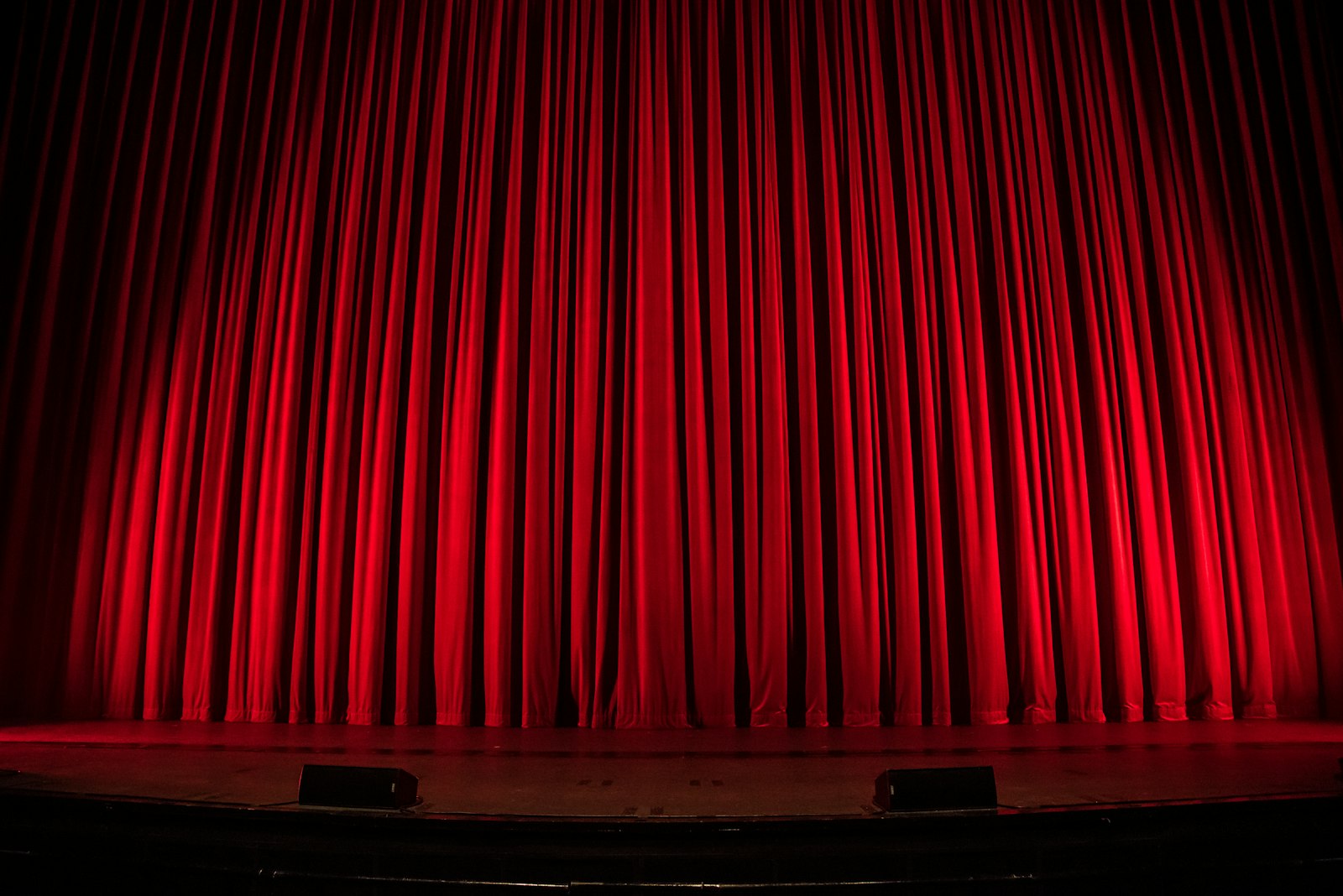 Il sipario rosso chiuso di un teatro, immagine d’atmosfera