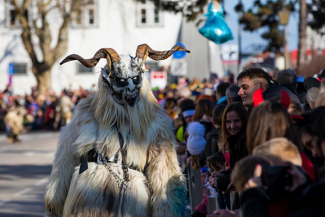 Maschera di Krampus con corna, pelliccia e campanacci durante una parata in Slovenia, fotografia d’archivio del 2023