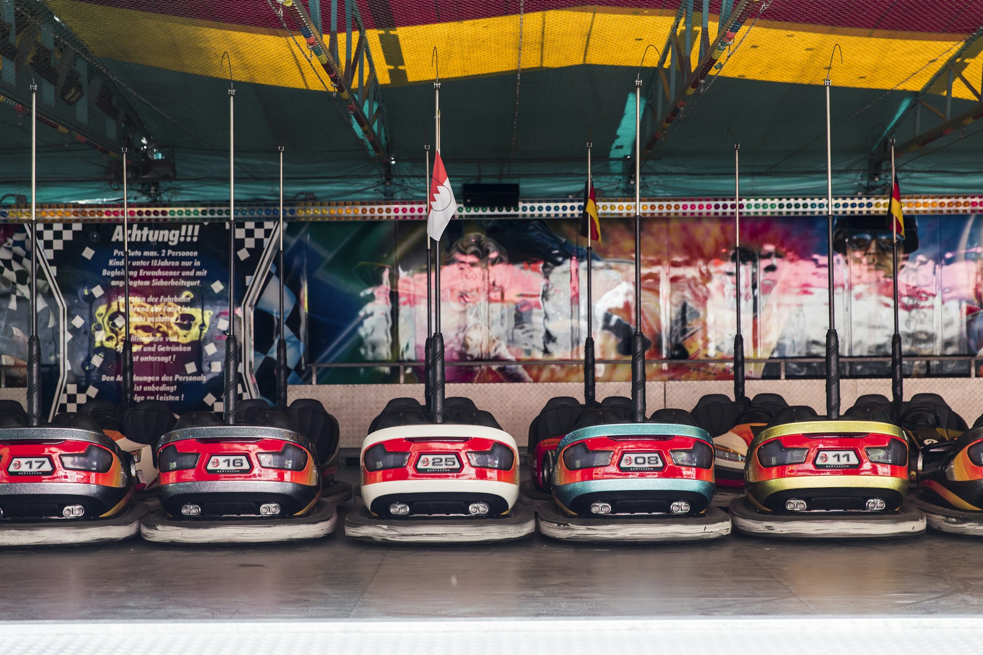 Una fila di autoscontro colorati sotto il tendone di un luna park